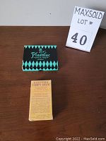 Two boxes: Plastilac playing cards box with green and black diamond pattern and Egyptian Tarot deck yellow box with printed text.