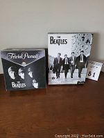 The Beatles Trivia Pursuit box and 1000-piece puzzle box shown side by side on a wooden surface.