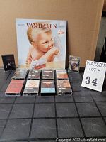 10 Van Halen audio cassette tapes arranged in two rows with one vinyl record sleeve depicting angel baby artwork in background