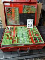Open red carrying case showing 6 trays filled with organized plastic building parts.