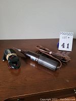 High frequency generator with its power cord, placed on a wooden surface with a lot number tag.