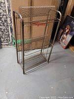 Metal vinyl record stand rack shown empty, made of tubular and wire grid metal.