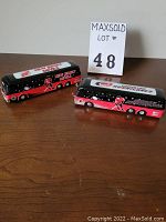 Photo of two White Rose Super Star coach models, New Jersey Devils and Carolina Hurricanes, side by side on a wooden surface showing their full length and graphics.