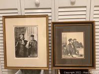 Photo of two framed black and white art prints by Honore Daumier, one larger titled 'Les Deux Avocats' and one smaller courtroom scene.