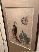 Close-up of full framed Japanese watercolor artwork depicting two traditional Japanese figures, with broad matting and dark wooden frame.