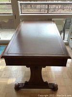 Top-down view of brown leather writing surface with gold tooled border
