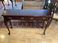 Front view of sofa table showing two drawers with brass handles and Queen Anne cabriole legs.