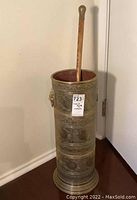 Full view of cylindrical brass umbrella stand with oak cane inserted