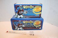 Front view of two stacked O-Pee-Chee 2002-03 NHL Hockey Cards factory sets in original packaging, showing colorful goalie image and product branding.