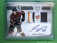 Front of the card showing Greg Nemisz in Calgary Flames jersey, two patch pieces and signature, serial numbered 05/15.