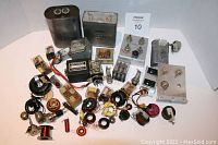 Overview of the electronic components and relay switches lot showing multiple items arranged on a white surface.