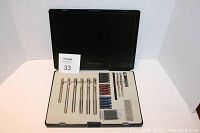Open presentation case showing six classic metal pens and multiple ink cartridges in different colors arranged neatly