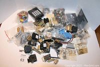 Image shows several bags and loose electronic connectors, switches, plugs, including a black keypad unit and multiple D-sub connectors.