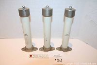 Photo showing all three LAPP steatite ceramic insulators on a white surface, highlighting the metal top fasteners and metal mounting base plates.