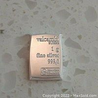 Close-up of the Valcambi Suisse 1 gram fine silver bar showing markings and assay stamp on a granite surface.