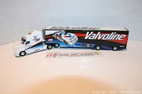 Side view of Valvoline NASCAR truck hauler model showing cab and trailer with Valvoline branding and race truck graphics