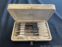Set of six antique knives with mother of pearl handles and sterling silver collars in a vintage fitted box