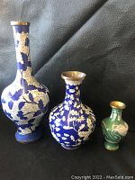 Three cloisonné vases of varying sizes with blue and green enamel and floral and dragon motifs