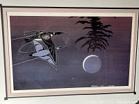 Full view of framed print showing bird flying over lake at night with moon and tree in distance.