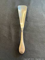 Shoe horn laid flat showing full length and shape.