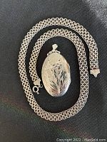 Chain laid flat around locket on black background