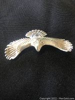 Front view of silver eagle pendant showing detailed feathers and wing spread.