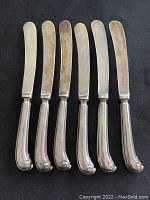 Full set of six vintage sterling silver butter knives arranged side by side showing blade and handle design.