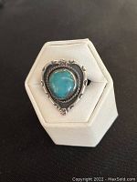 Front view of the sterling silver Southwestern style ring with turquoise stone on display stand.