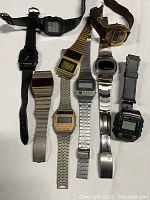 Overview of eight vintage digital wristwatches laid out on white background
