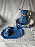 Full set of blue ceramic wash basin, pitcher, tray, powder jars, and bottle with floral and bird design showing all pieces.