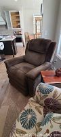 Brown upholstered Lazyboy power lift recliner chair angled to show side and front.