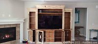 Front view of HOOKER Furniture lighted wall entertainment unit with TV space, shelving, drawers, and cabinets