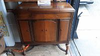 Front view of Victor gramophone cabinet showing doors and wooden legs with stretcher.