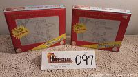 Pair of unopened vintage Magic Etch A Sketch boxes shown from front, depicting the product with graphics and key text.