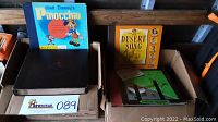 Photo of vintage vinyl records including Walt Disney's Pinocchio, The Desert Song, and others stacked in cardboard boxes.
