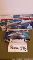 Three vintage Revell model kits boxes including Enterprise with Booster Rockets, Enterprise + Space Lab, and another Enterprise kit beneath them.