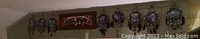 Long view showing the full set of three wolf-themed dream catchers and the personalized bar sign hanging above them on a wall.