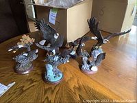 Four eagle sculptures arranged on wooden tabletop