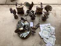 Several resin eagle sculptures and paperwork spread on concrete floor