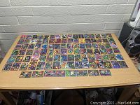 Large collection of Marvel comic collector cards laid out on a table showing full spread of various characters and scenes.