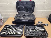 Full overview of the Husky tool case open with multiple trays showing sockets and wrenches organized inside.