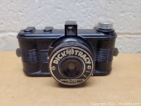 Front view of vintage Dick Tracy Bakelite camera showing the Dick Tracy branding on the lens and textured body.