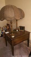 Deilcraft wooden end table with two vintage cane shade table lamps and vintage clock on top