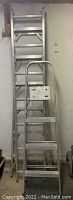 Two aluminum ladders shown standing against a wall, one tall extension ladder and one three-step ladder with small platform.