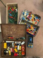 Vintage die cast cars and trucks in a suitcase with additional loose die cast car