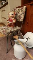 Bear-shaped vintage ceramic cookie jar on floral upholstered chrome frame chair with white enamel pitcher and wooden spoon in front