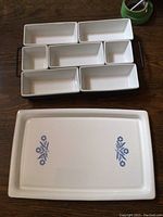 Top view of metal wire multi-server rack holding six white ceramic dishes with varying rectangular sizes.