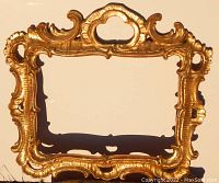 Front view showing ornate carved and gilded wood frame with elaborate scroll design.