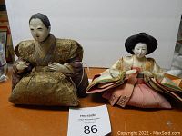 Pair of antique Japanese Hina Ningyo dolls seated side by side on a flat surface with plain white background.