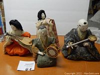 Overview of four Hina Ningyo dolls: three seated musicians with instruments and one standing attendant